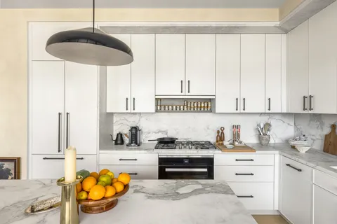 a kitchen with a stove cabinets and a window
