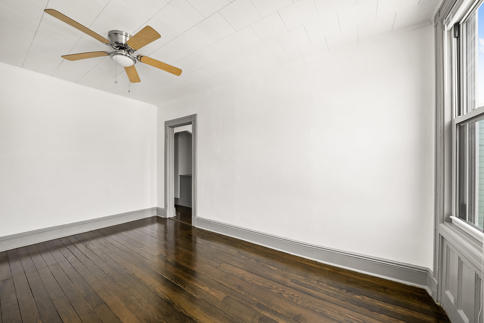 59-45 Palmetto Street Queens, NY 11385 - Photo 4 of 25 a view of an empty room with wooden floor and a window
