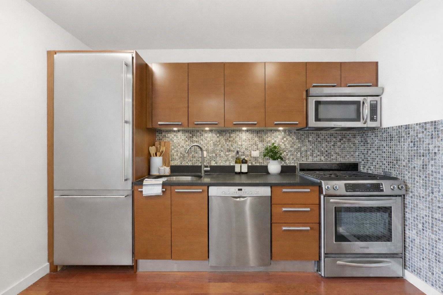 1485 5th Avenue, Unit 12G Manhattan, NY 10035 - Photo 5 of 14 a kitchen with stainless steel appliances granite countertop a stove a sink and a refrigerator