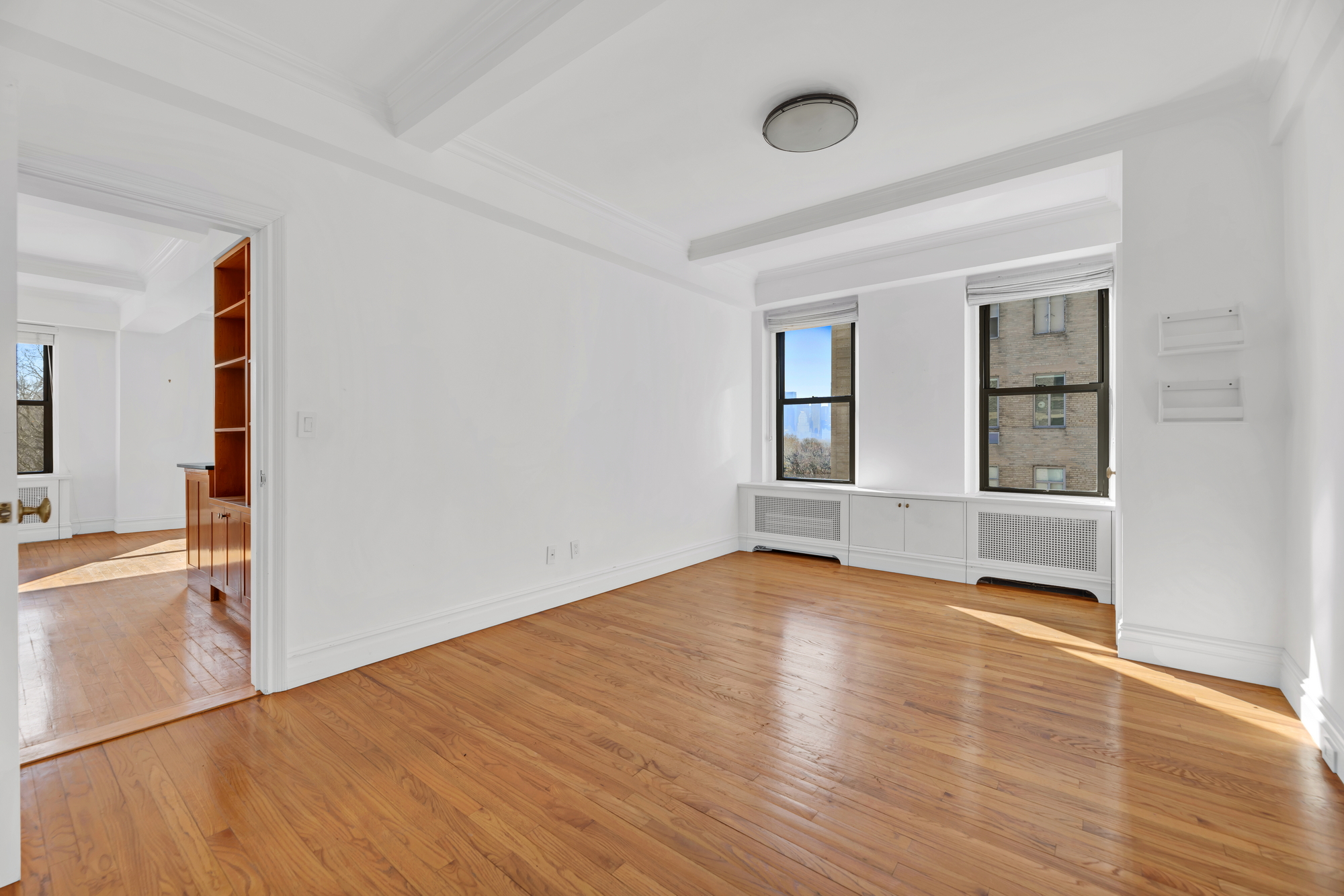 225 Central Park West, Unit 801 Manhattan, NY 10024 - Photo 14 of 21 an empty room with wooden floor and windows