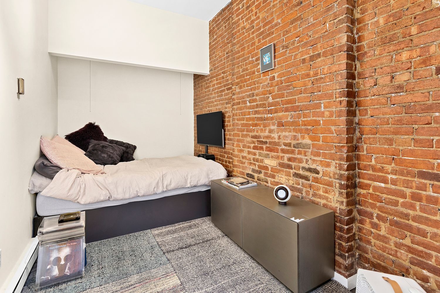 344 West End Avenue, Unit 6 Manhattan, NY 10024 - Photo 4 of 6 a bedroom with a bed and a brick wall