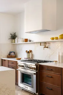 a white stove top oven sitting inside of a kitchen