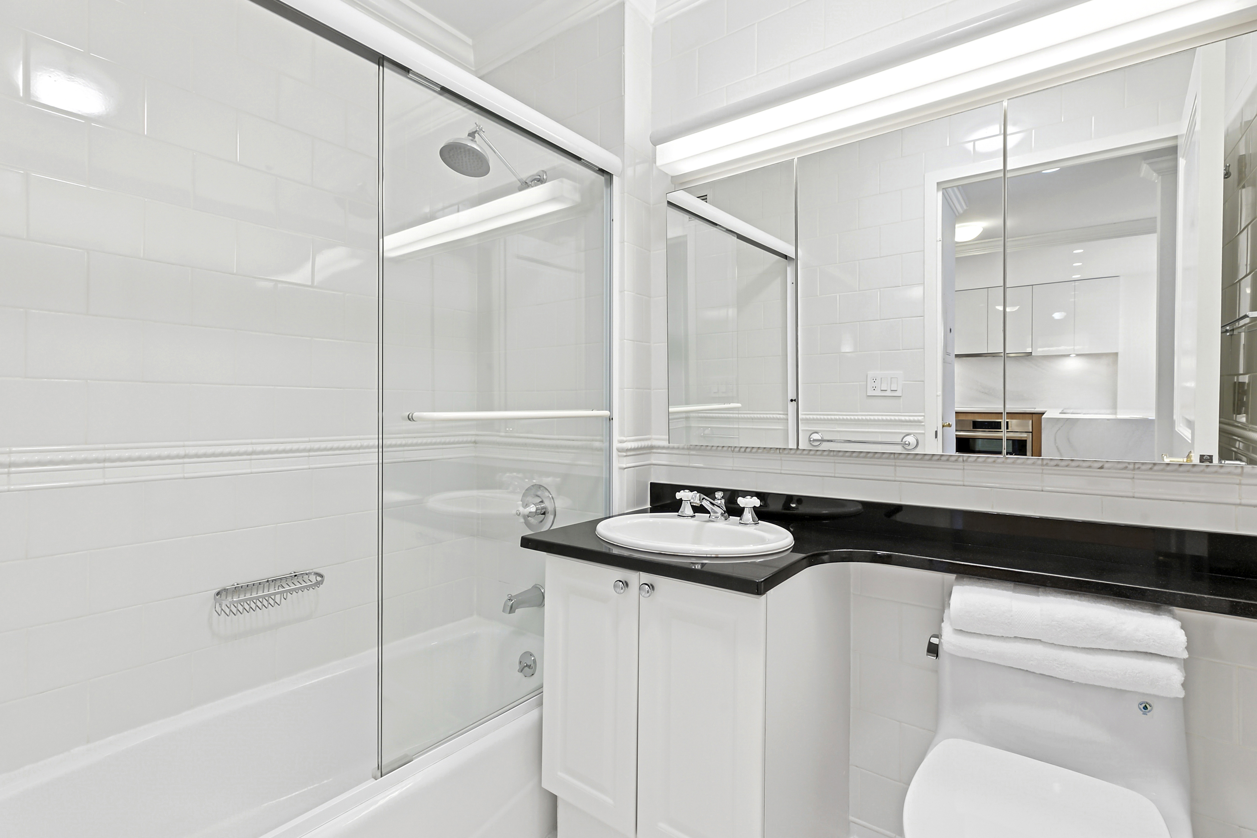 350 East 82nd Street, Unit 4C Manhattan, NY 10028 - Photo 6 of 13 a bathroom with a sink a toilet and shower