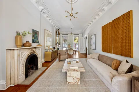 a living room with furniture a fireplace and a chandelier