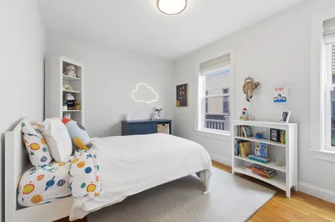 a bedroom with a bed and a book shelf