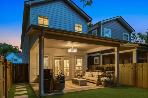 a backyard of a house with yard table and chairs