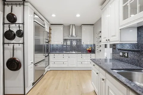a kitchen with granite countertop stainless steel appliances a refrigerator and cabinets