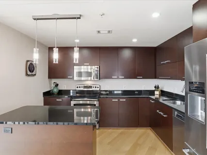 a large kitchen with granite countertop a sink stainless steel appliances and cabinets