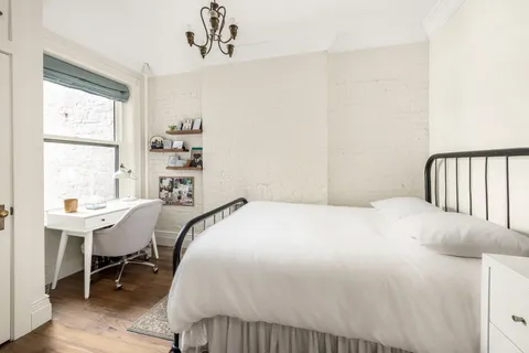 a bedroom with a bed a table and chair