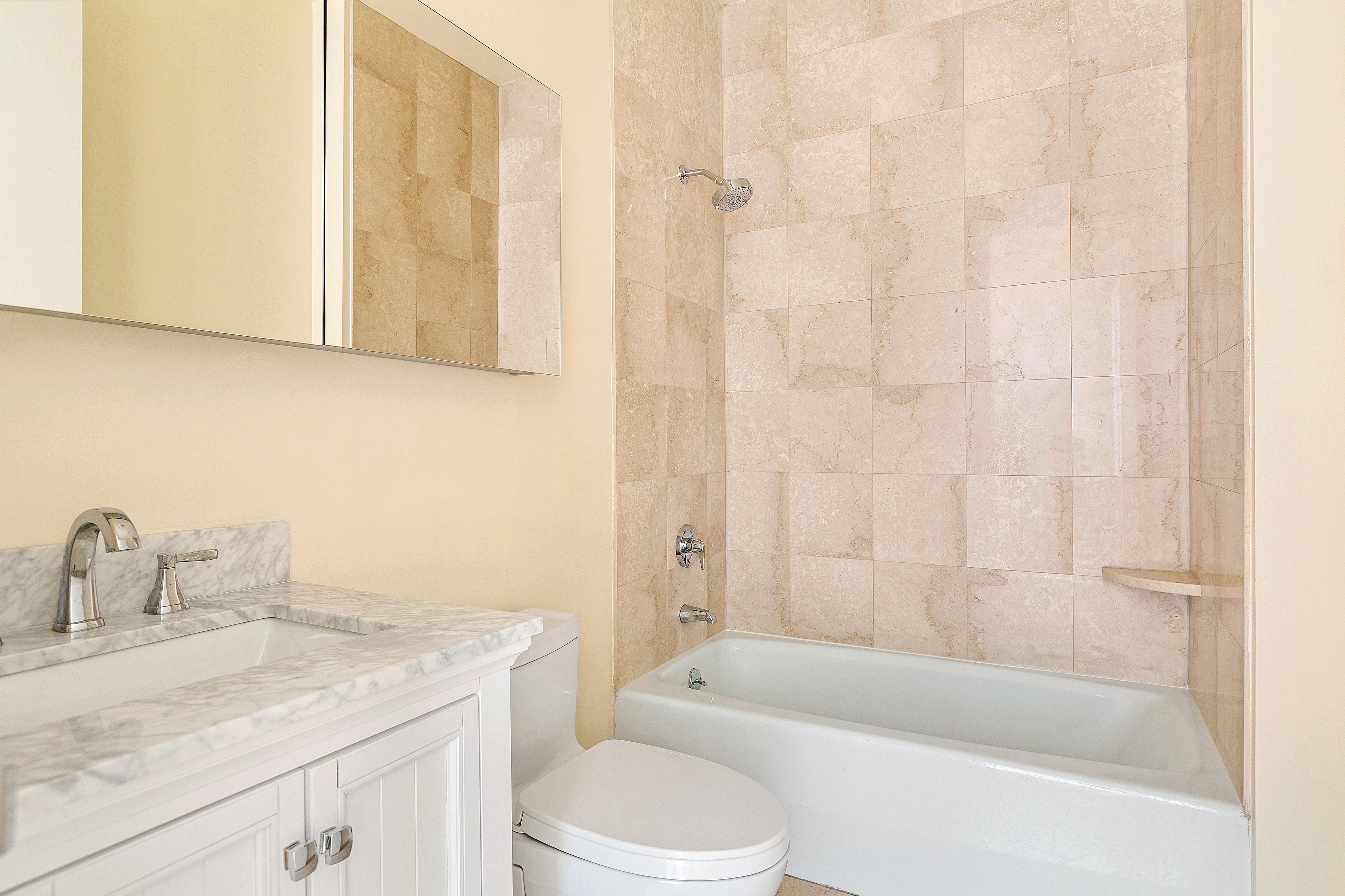 120 East 87th Street, Unit R10C Manhattan, NY 10128 - Photo 7 of 13 a bathroom with a granite countertop sink toilet and shower