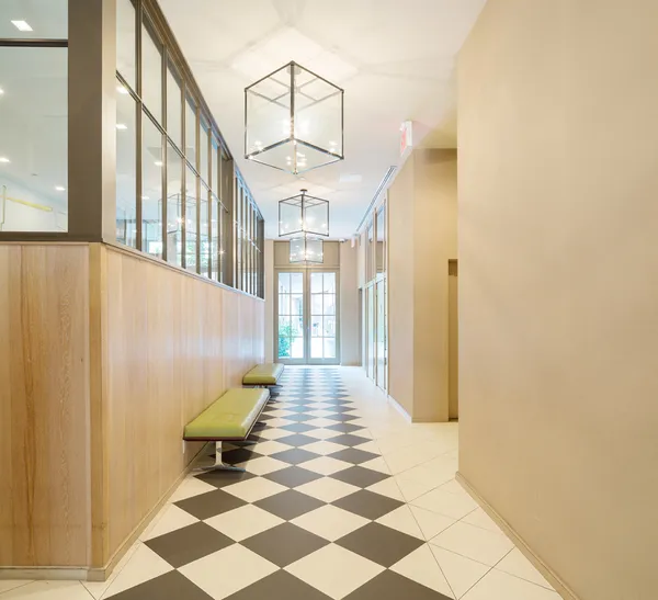 a view of a hallway with wooden floor and a living room