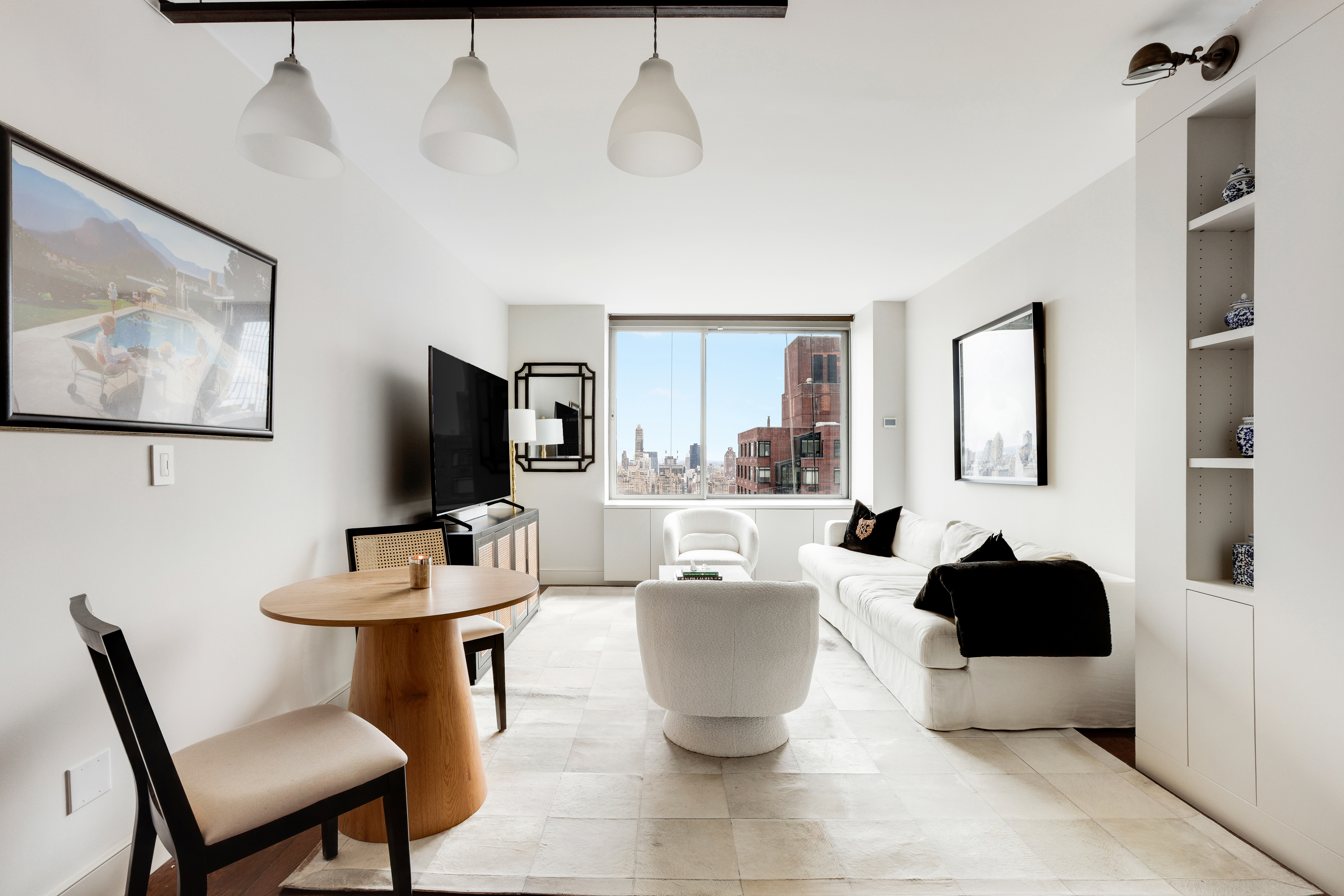 111 West 67th Street, Unit 34F Manhattan, NY 10023 - Photo 2 of 11 a living room with furniture a flat screen tv and kitchen view