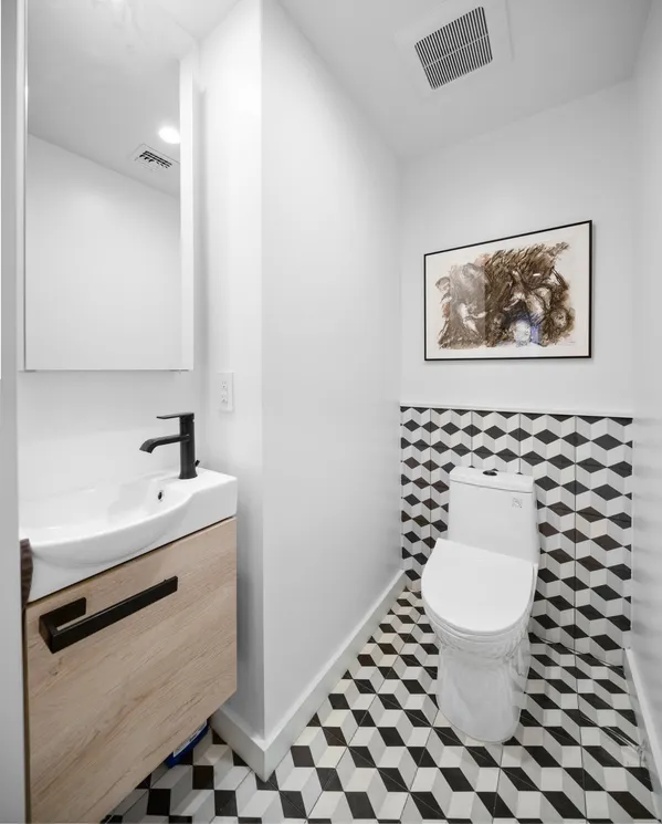 a bathroom with a toilet sink and mirror