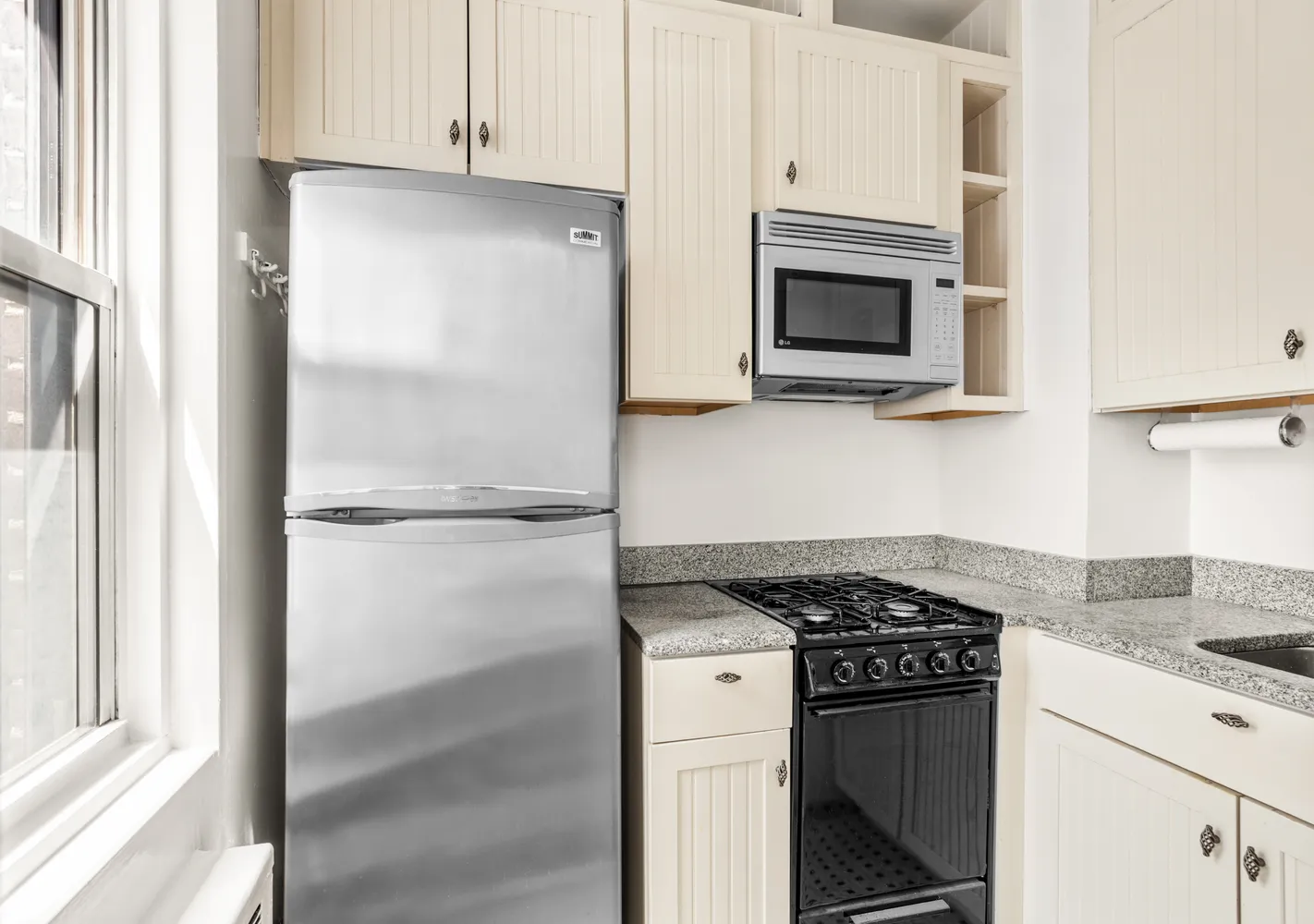 a kitchen with a refrigerator stove and microwave
