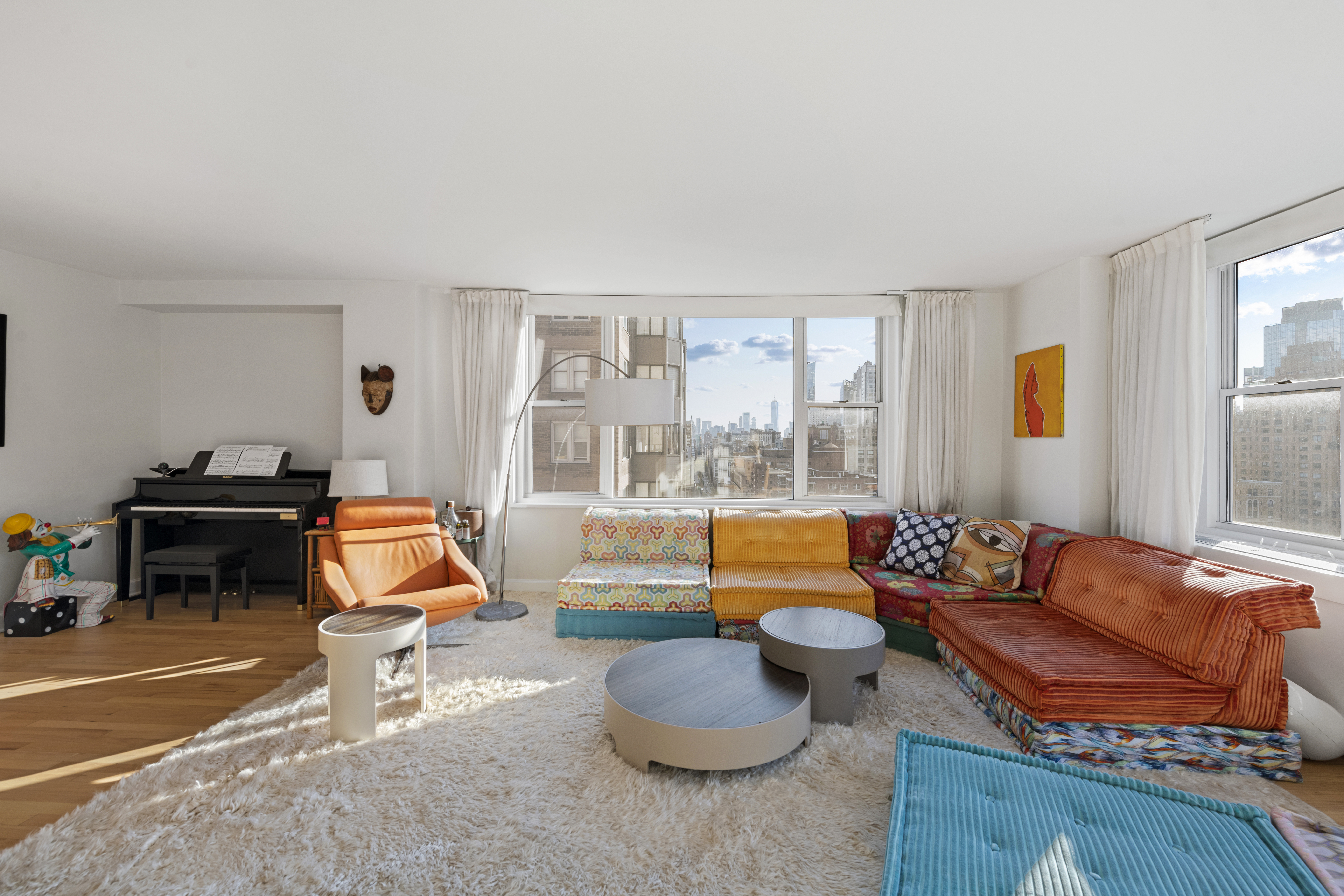 137 East 36th Street, Unit 21F Manhattan, NY 10016 - Photo 5 of 20 a living room with furniture and a floor to ceiling window