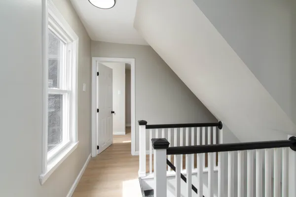 a view of a hallway with wooden floor and staircase
