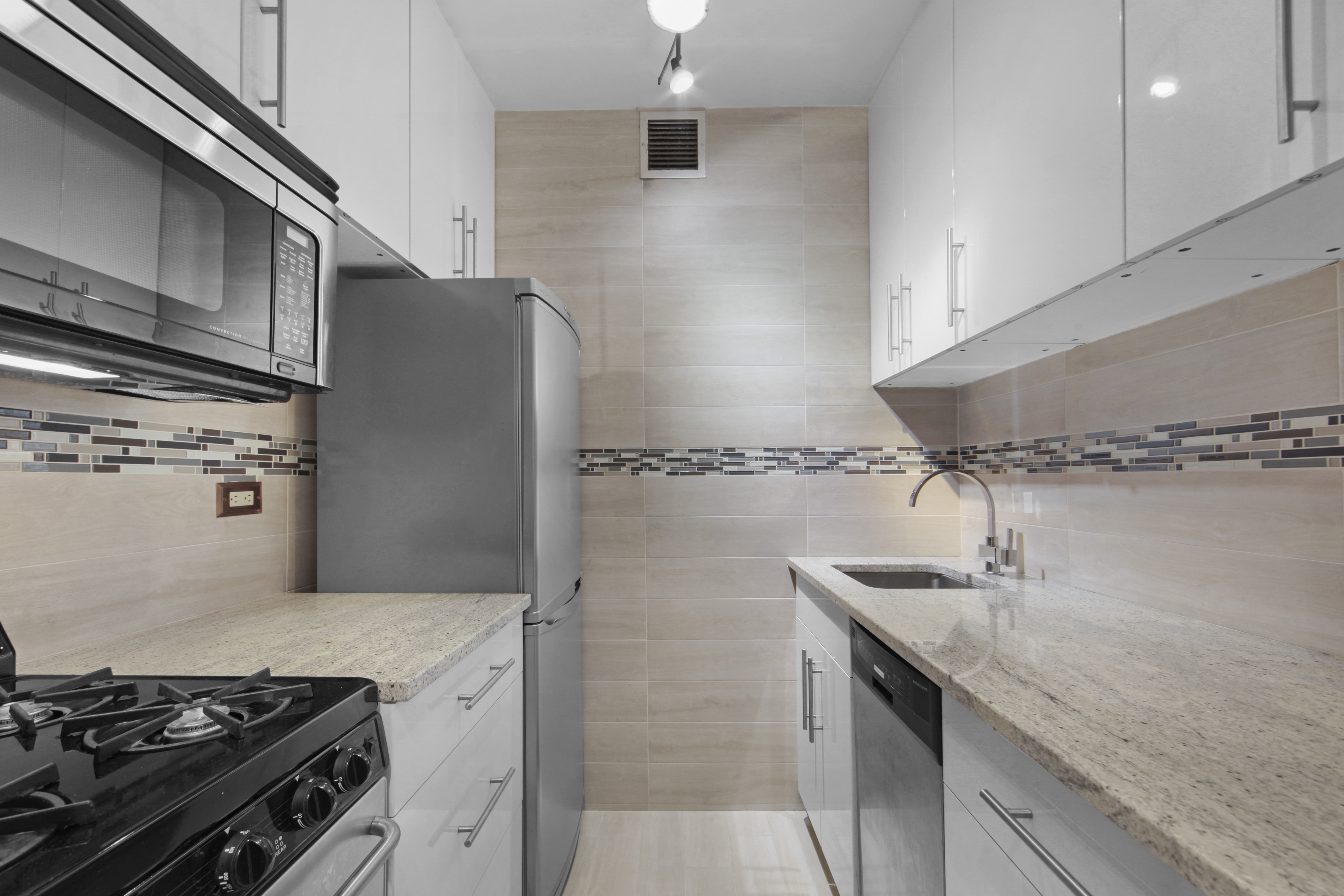 160 East 65th Street, Unit 8A Manhattan, NY 10065 - Photo 9 of 13 a kitchen with stainless steel appliances granite countertop a sink stove and refrigerator