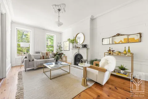 a living room with furniture a fireplace and a large window