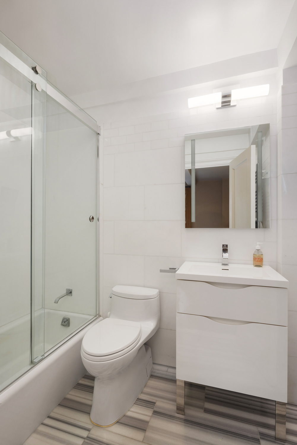 45 Christopher Street, Unit 2E Manhattan, NY 10014 - Photo 13 of 15 a bathroom with a toilet a sink and mirror