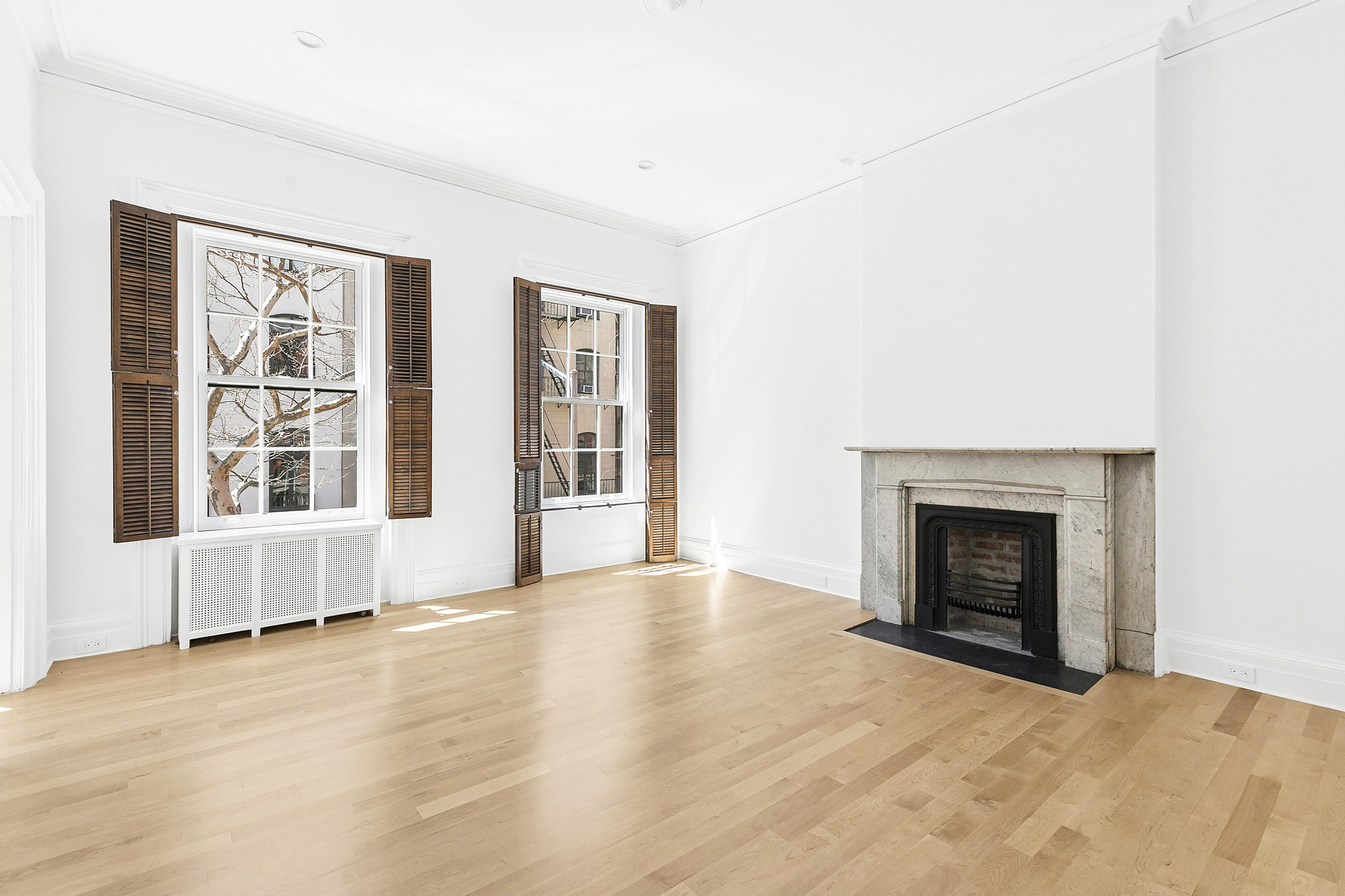 221 East 17th Street, Unit 2 Manhattan, NY 10003 - Photo 5 of 9 a view of an empty room with window and fire place