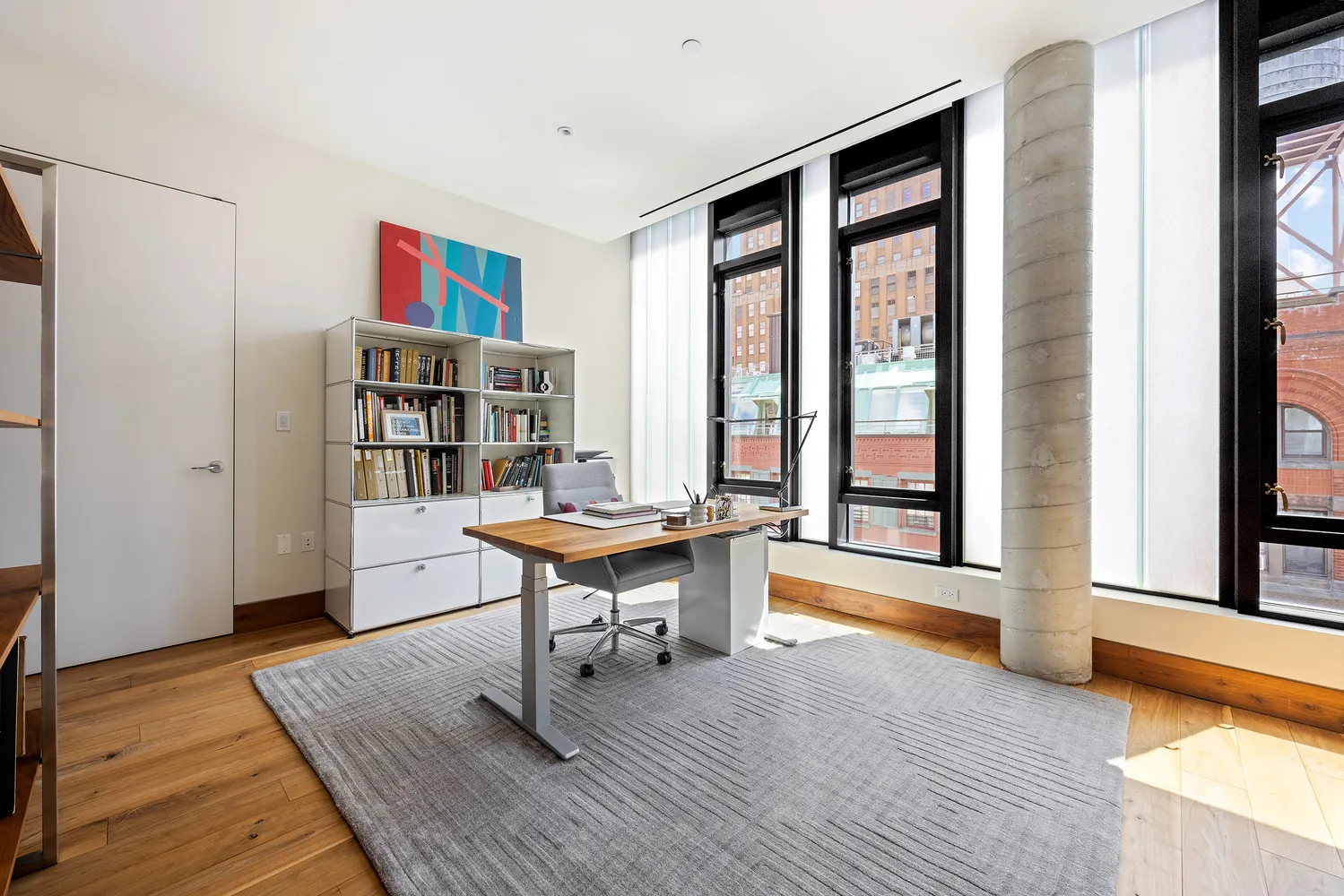 a view of a workspace with furniture and a window