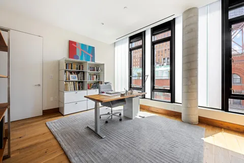 a view of a workspace with furniture and a window