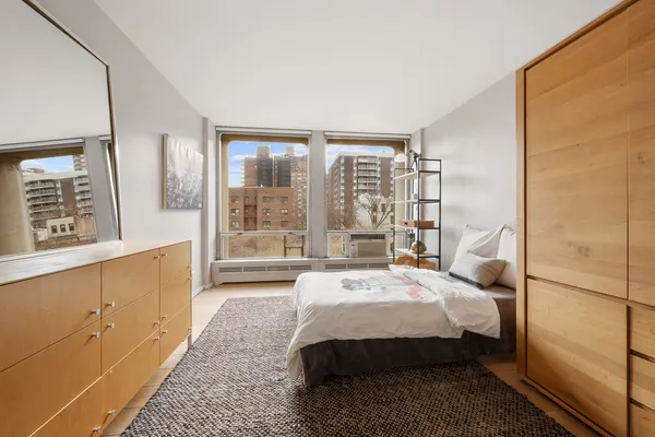 a bedroom with a bed and a large window