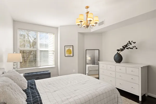 a bedroom with a large bed and a chandelier
