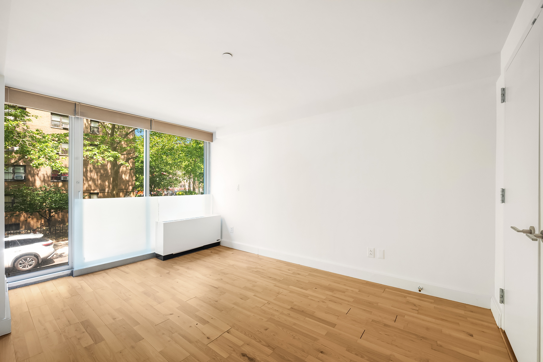 420 West 25th Street, Unit 2K Manhattan, NY 10001 - Photo 8 of 18 an empty room with wooden floor and windows