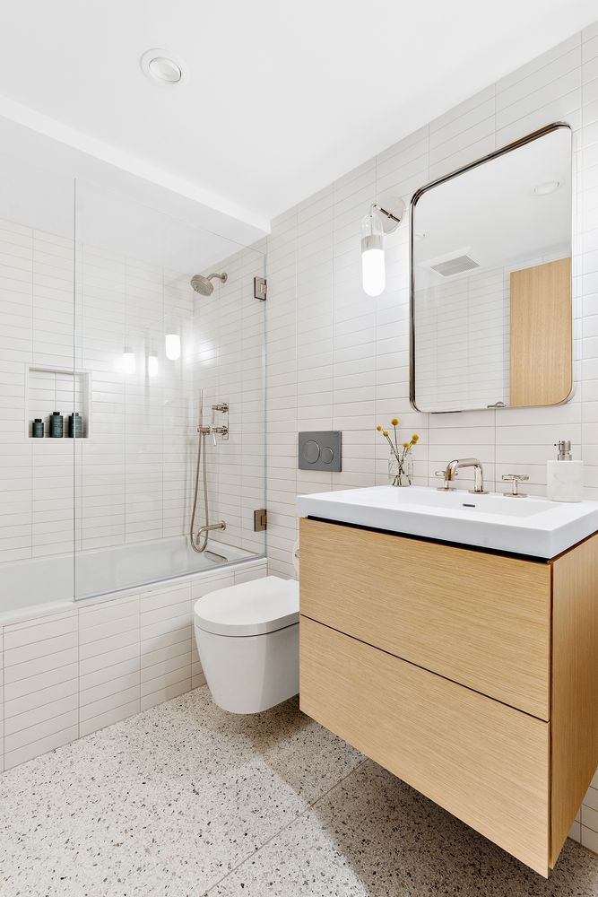 a bathroom with a double vanity sink mirror and bathtub