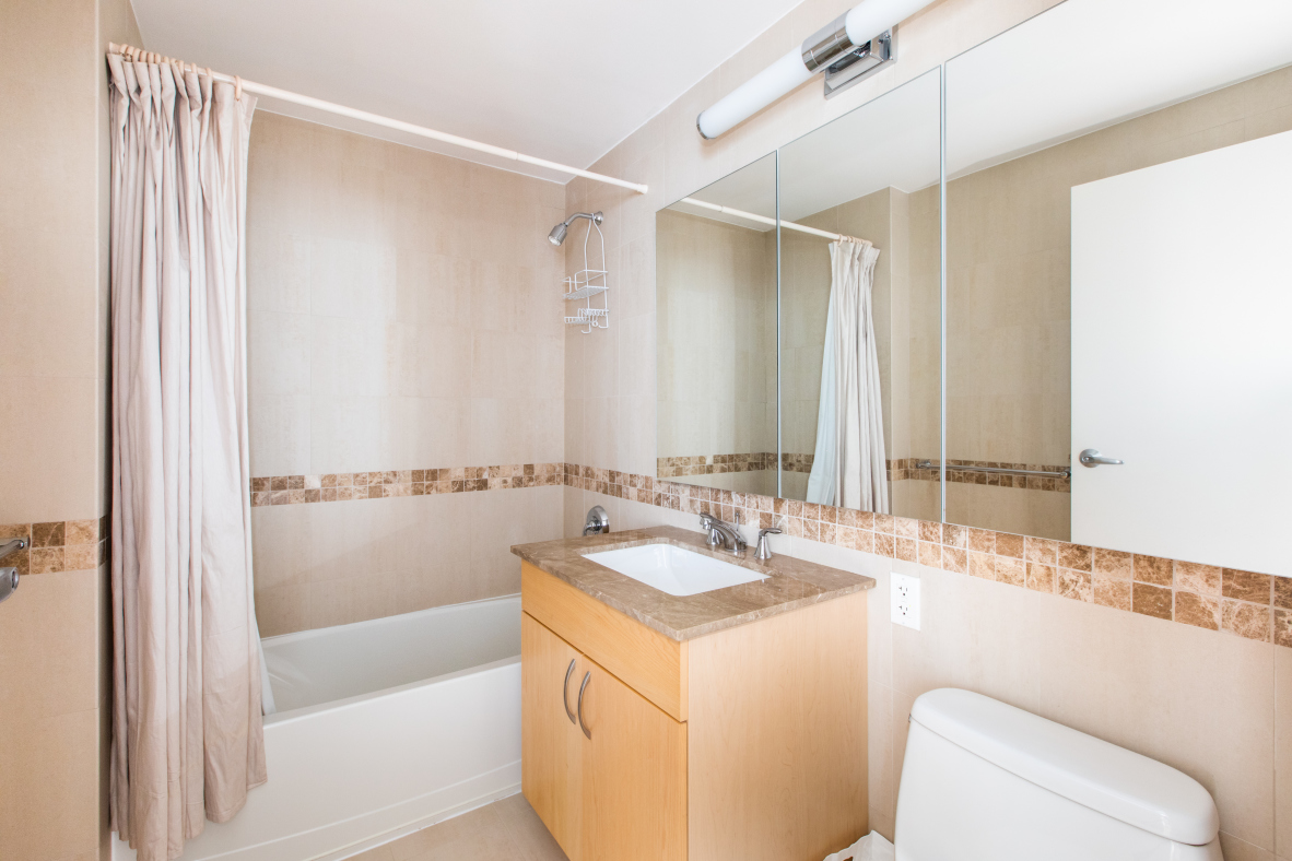 40 West 116th Street, Unit A406 Manhattan, NY 10026 - Photo 9 of 14 a bathroom with a granite countertop sink and a mirror