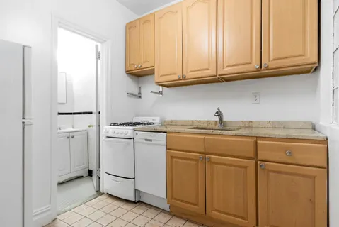 a kitchen with white cabinets and white appliances