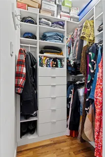 a view of walk in closet with clothes and shoes