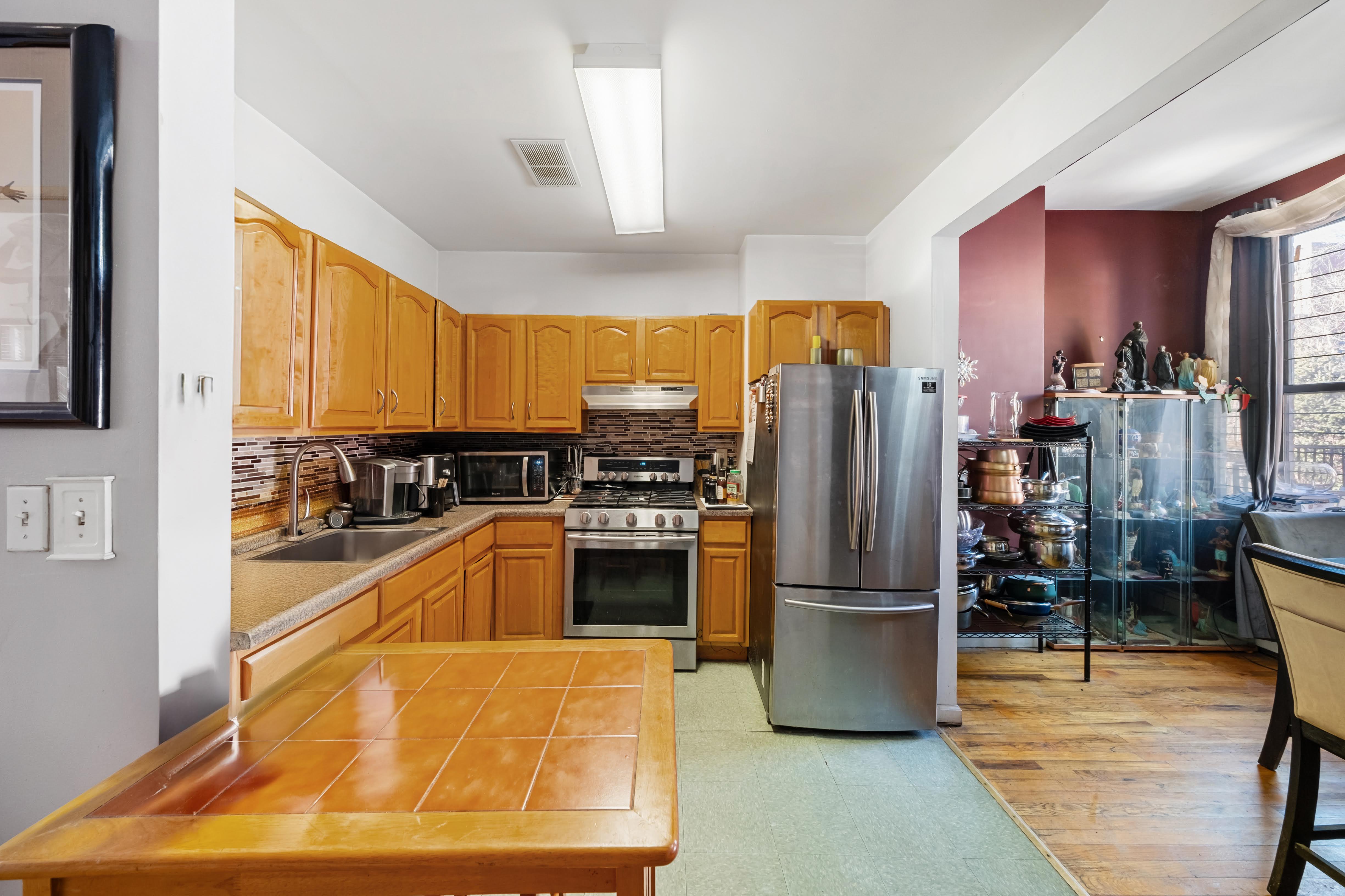 275 Van Buren Street Brooklyn, NY 11221 - Photo 5 of 33 a kitchen with stainless steel appliances granite countertop a refrigerator a stove and a sink with cabinets