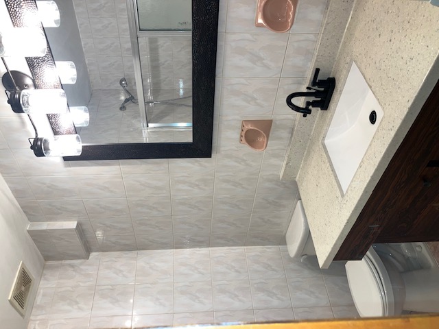 1653 West 9th Street, Unit 2 Brooklyn, NY 11223 - Photo 4 of 7 a bathroom with a sink a toilet and shower