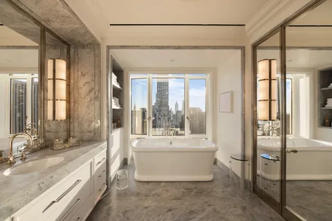 a bathroom with a double vanity sink a mirror and a bathtub