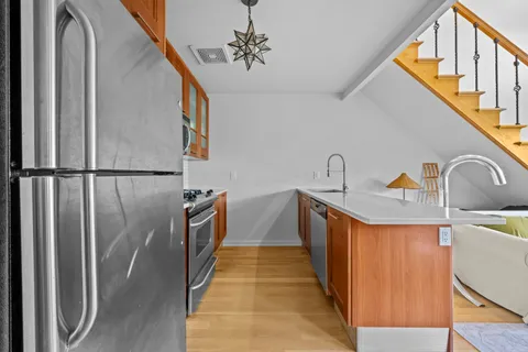 a hallway with stainless steel appliances a sink and cabinets