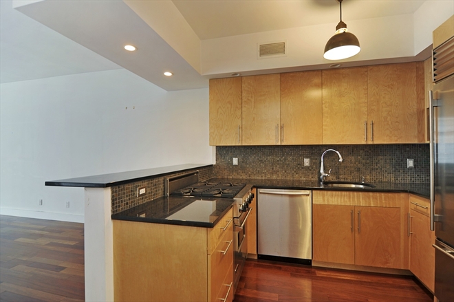 300 Spring Street, Unit 3B Manhattan, NY 10013 - Photo 3 of 4 a kitchen with granite countertop a sink a stove and cabinets