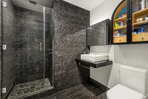 a bathroom with a sink a toilet and shower