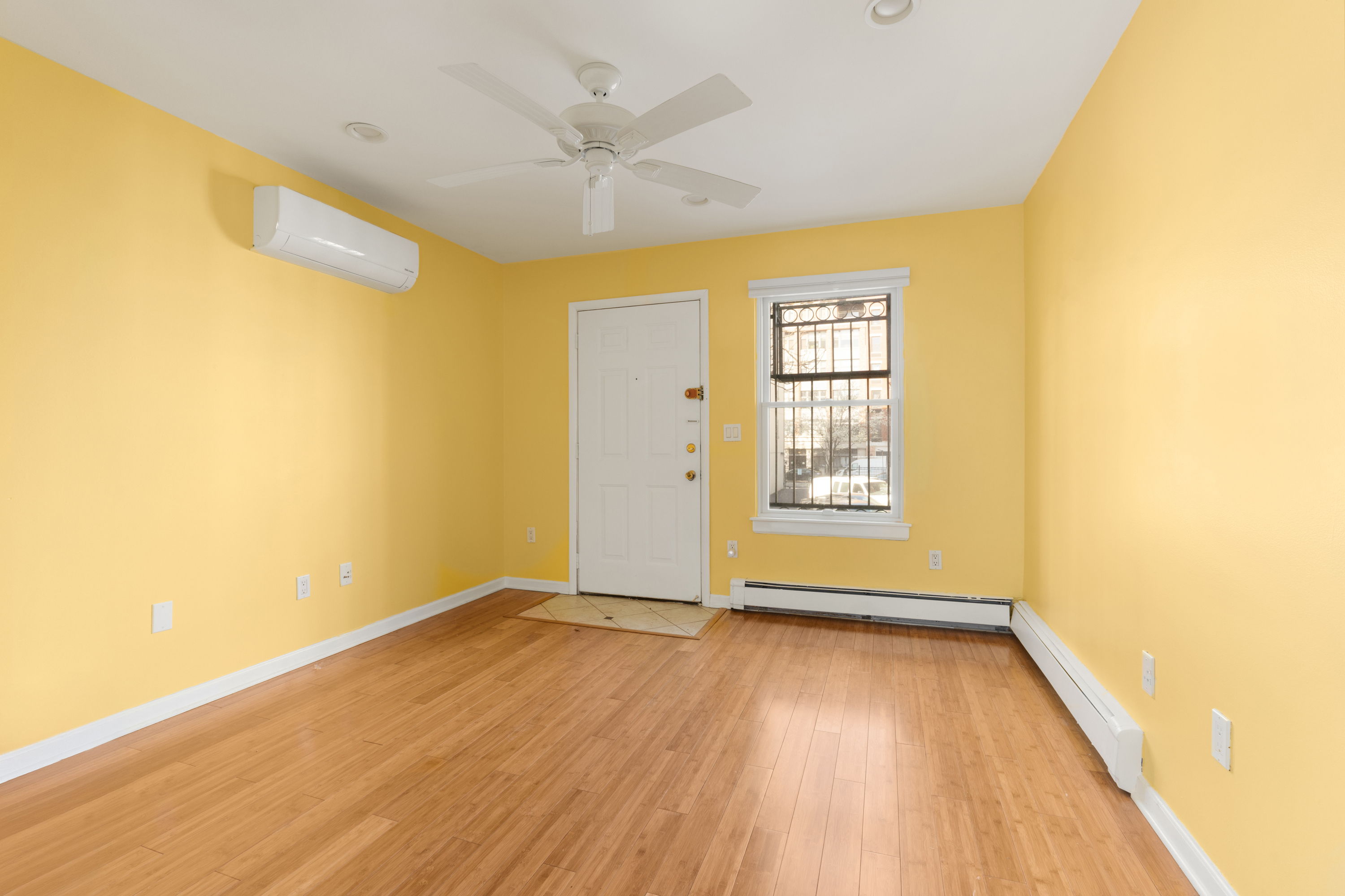 231 East 110th Street Manhattan, NY 10029 - Photo 6 of 11 a view of an empty room with wooden floor and a window