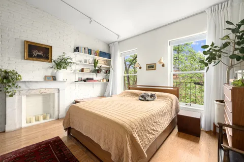 a bedroom with a bed dresser and a window