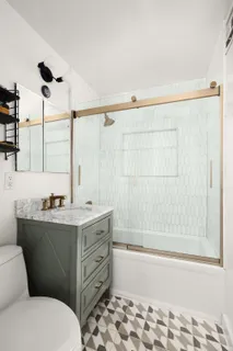 a bathroom with a granite countertop sink toilet and shower