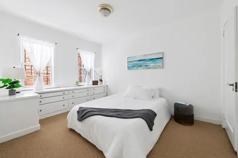 a bedroom with a bed and a large window