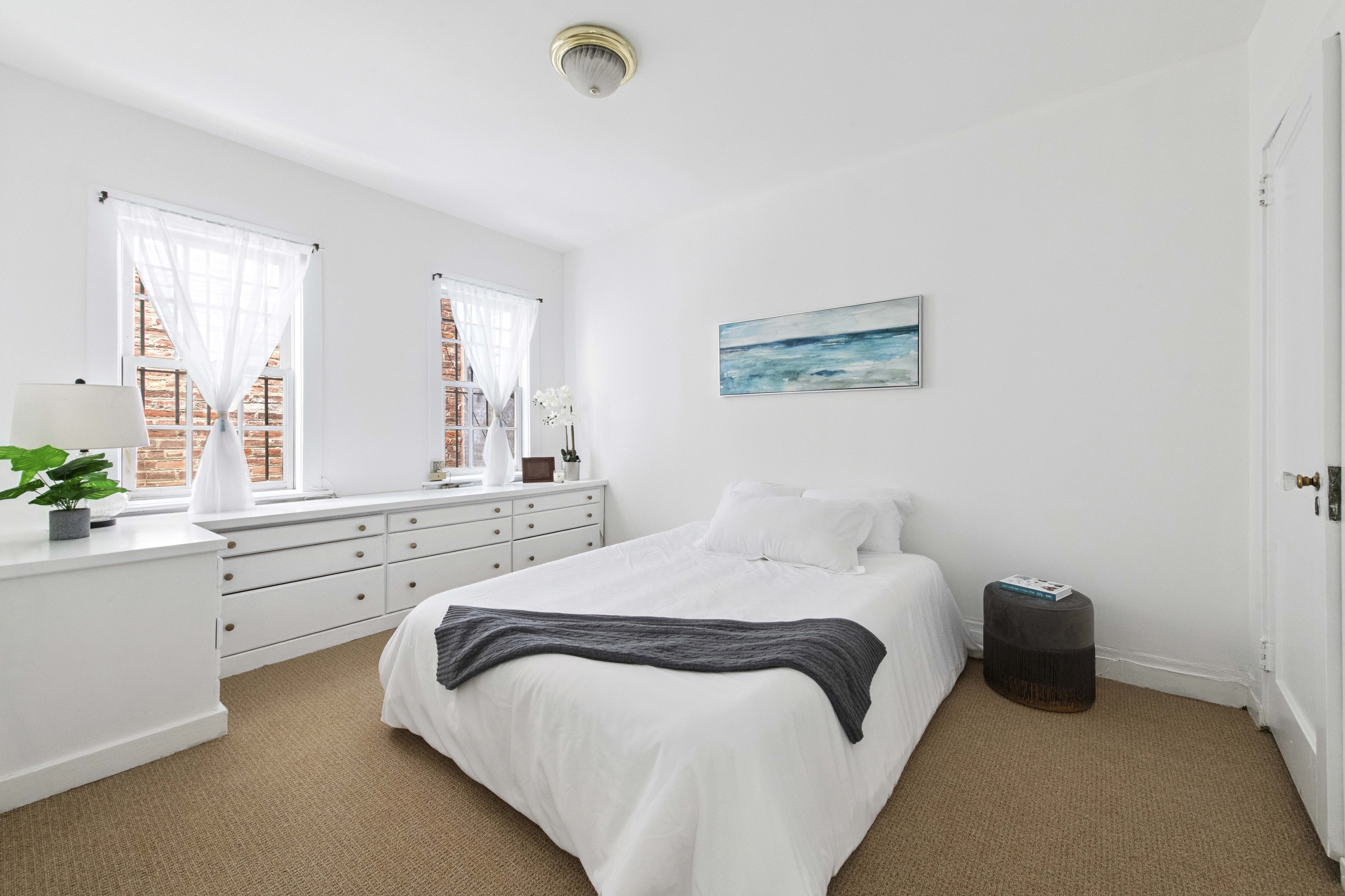 10 Pomander Walk, Unit 1 Manhattan, NY 10025 - Photo 7 of 13 a bedroom with a bed and a large window