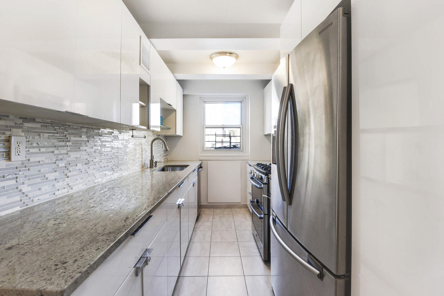 520 East 76th Street, Unit 11C Manhattan, NY 10021 - Photo 3 of 15 a kitchen with granite countertop a refrigerator and a sink