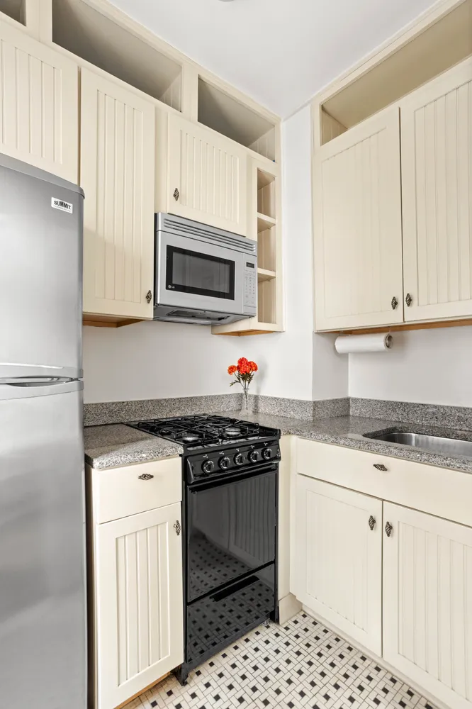 a kitchen with granite countertop a stove sink and microwave