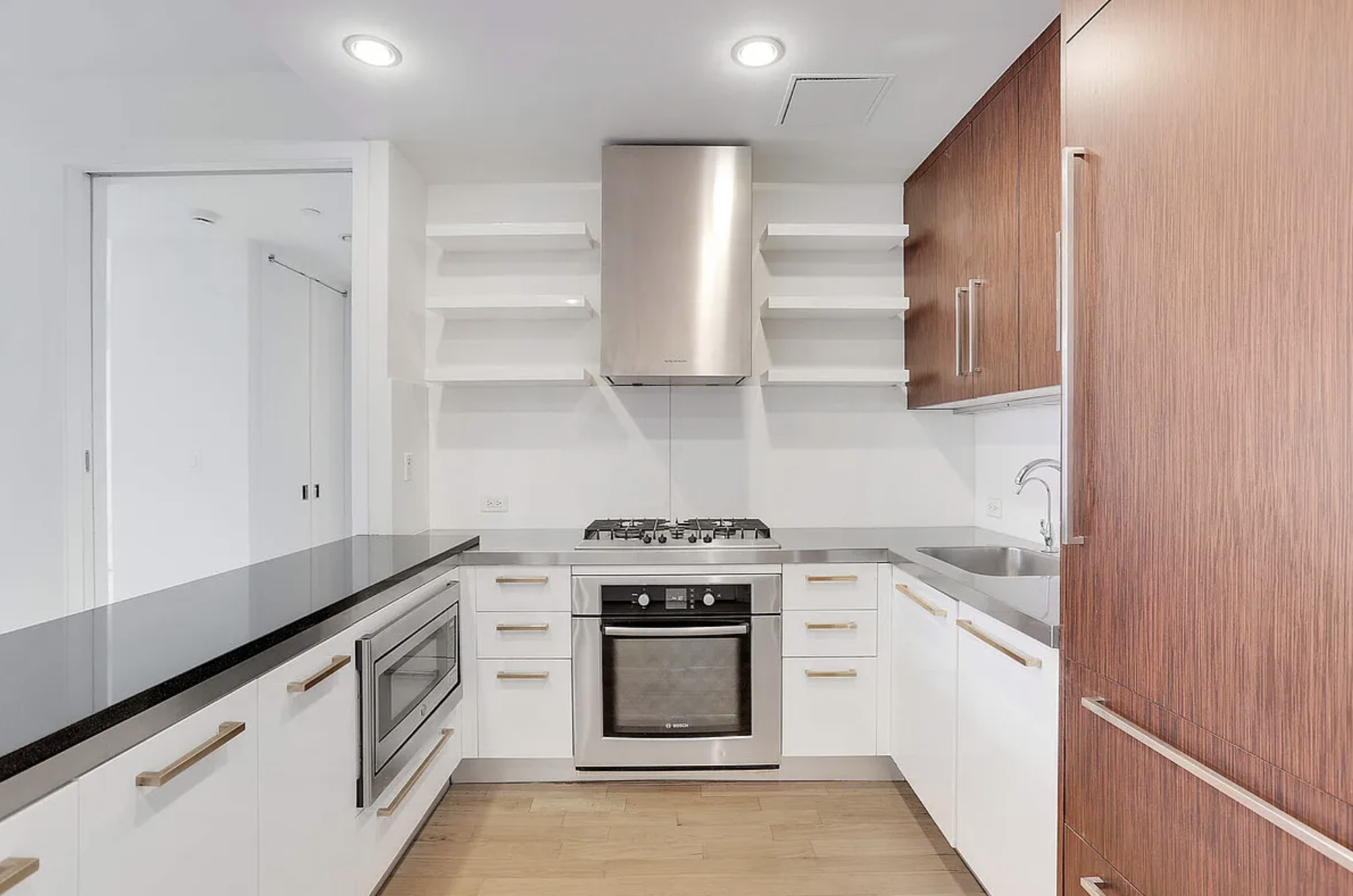 133 West 22nd Street, Unit 7H Manhattan, NY 10011 - Photo 6 of 22 a kitchen with stainless steel appliances granite countertop white cabinets and a stove top oven