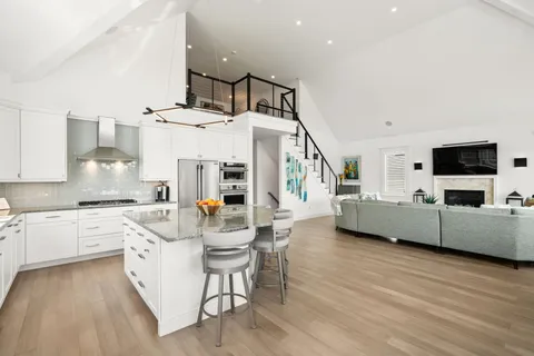 a kitchen with stainless steel appliances kitchen island granite countertop a stove a sink and a refrigerator