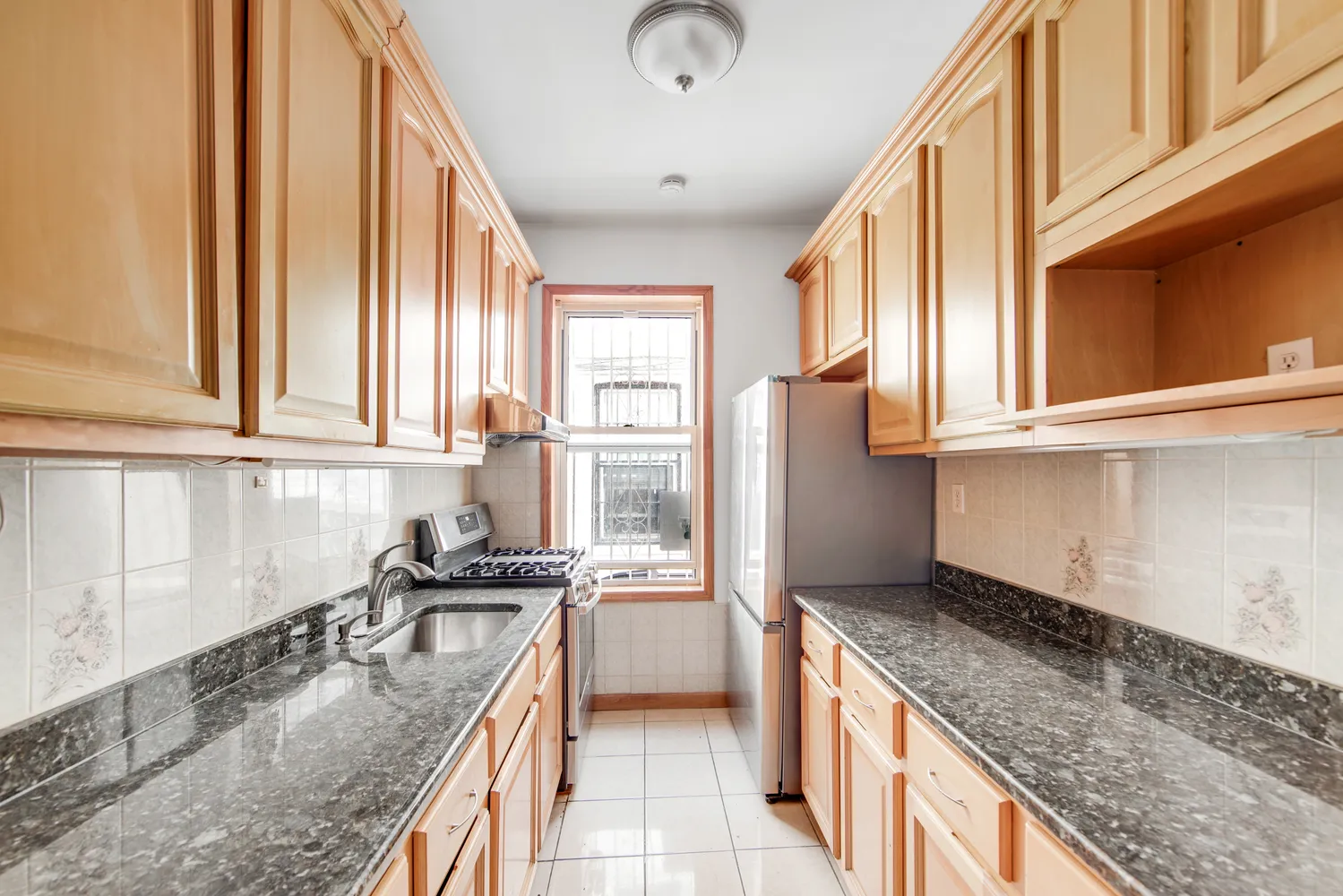 a kitchen with granite countertop a sink a counter top space and stainless steel appliances