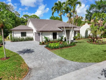 a front view of a house with a garden and yard